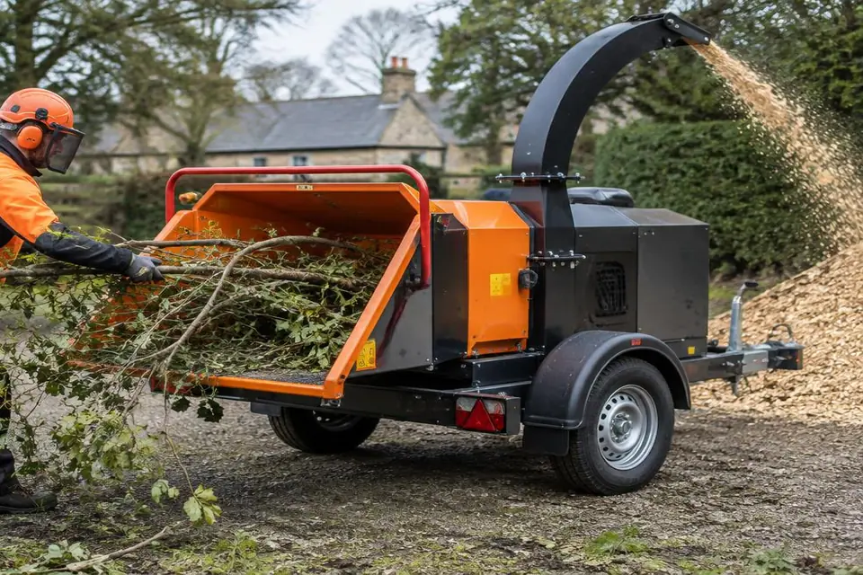 A tree surgeon using a professional towable wood chipper, showing equipment detail for a finance assessment.